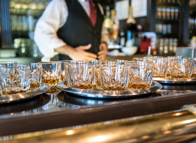 A closeup shot of glasses filled with whiskey at the bar